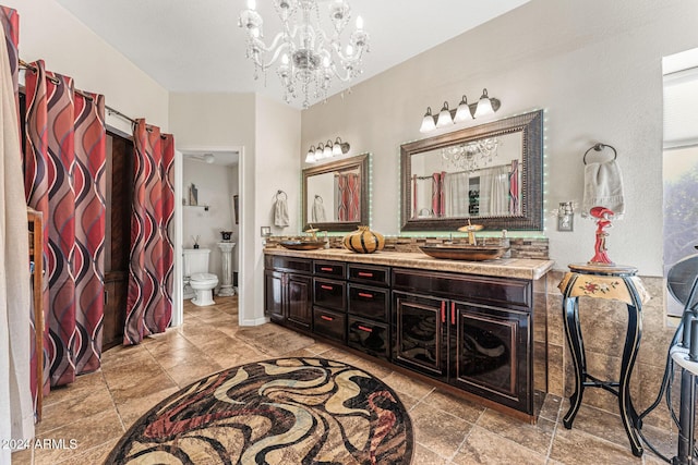 bathroom featuring a chandelier, vanity, and toilet