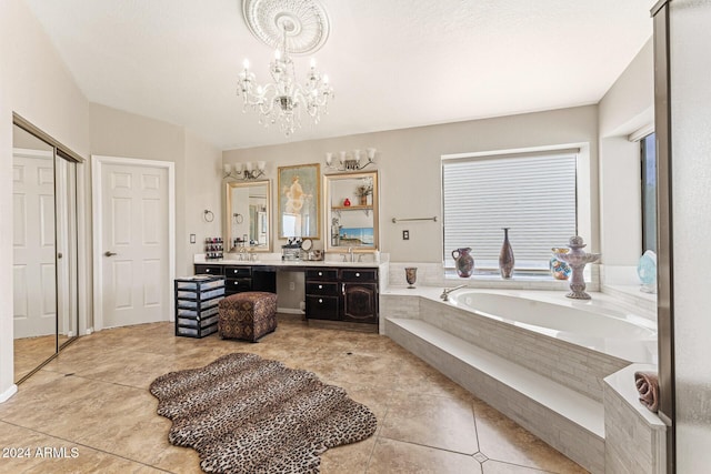 bathroom with tile patterned flooring, vanity, a relaxing tiled tub, and an inviting chandelier