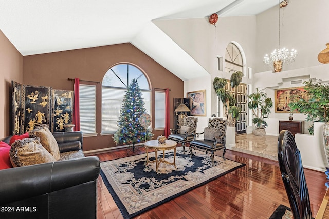 living room featuring hardwood / wood-style flooring, lofted ceiling, and an inviting chandelier