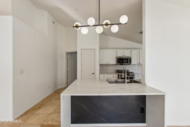 kitchen with stainless steel microwave, light stone counters, hanging light fixtures, white cabinetry, and a sink