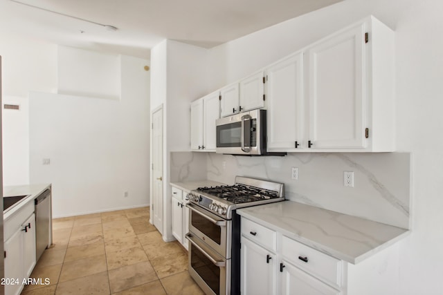 kitchen with decorative backsplash, appliances with stainless steel finishes, and white cabinets