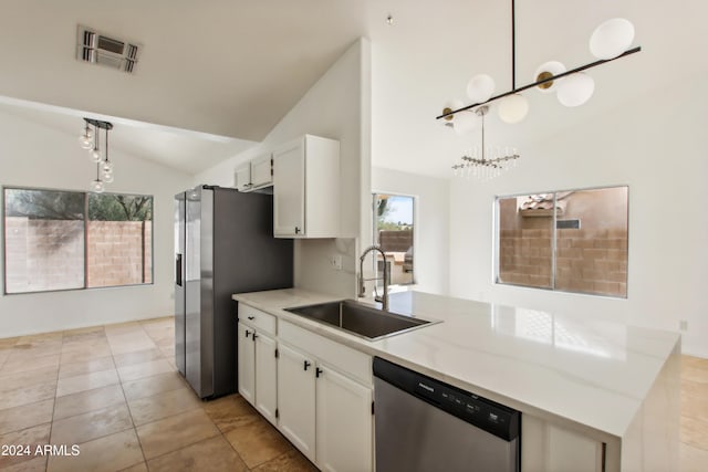 kitchen featuring a peninsula, a sink, vaulted ceiling, appliances with stainless steel finishes, and white cabinetry