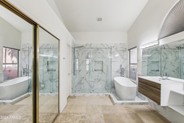 full bath with a marble finish shower, a soaking tub, and vanity