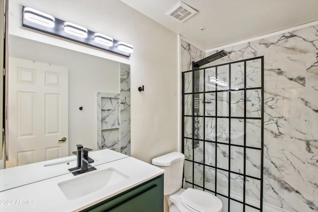 bathroom with a tile shower, visible vents, toilet, and vanity