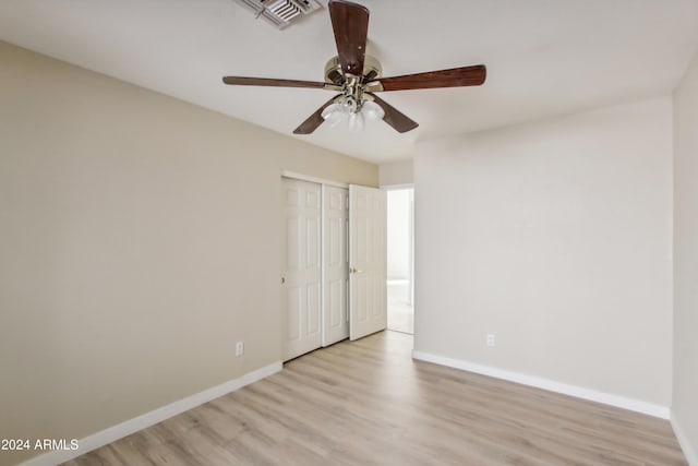 spare room featuring light wood-type flooring, visible vents, baseboards, and ceiling fan