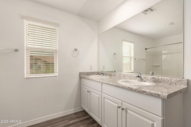 3713 S 54th Ln, Phoenix, AZ 85043 - full bathroom featuring wood finished floors, baseboards, double vanity, and a shower