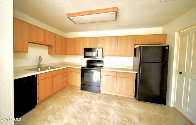 kitchen featuring light brown cabinets, sink, a textured ceiling, and black appliances