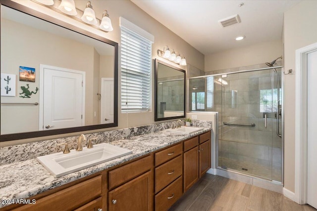 bathroom with vanity, hardwood / wood-style floors, and a shower with door