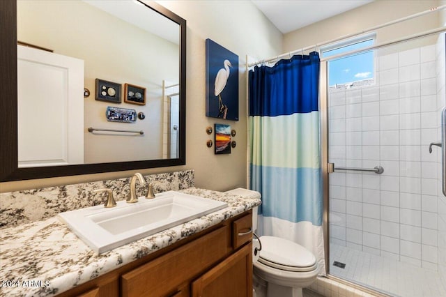 bathroom featuring curtained shower, vanity, and toilet