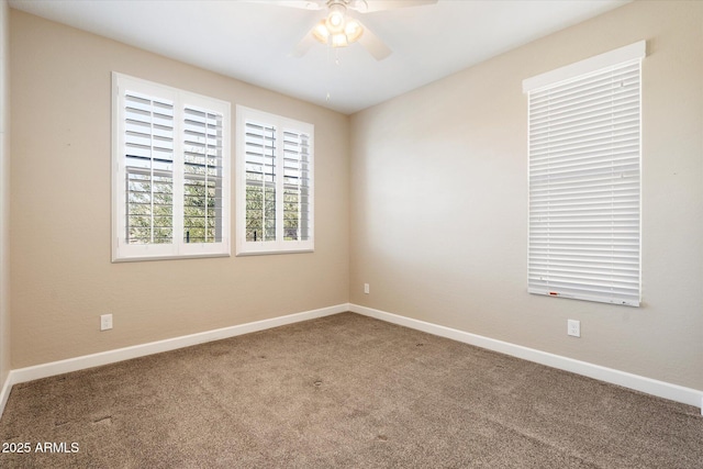 spare room featuring ceiling fan, carpet, and baseboards