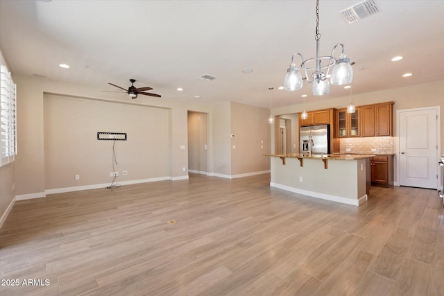 unfurnished living room with light wood-style floors, baseboards, visible vents, and recessed lighting