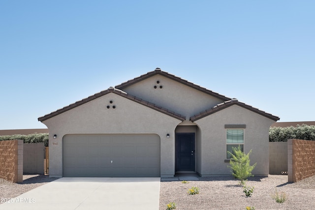 mediterranean / spanish-style house featuring driveway, a garage, stucco siding, fence, and a tiled roof
