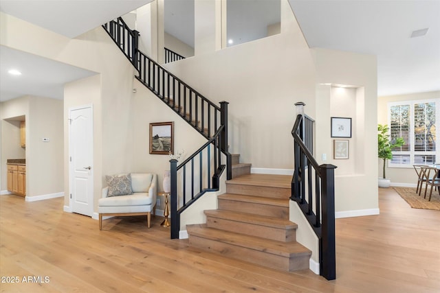 stairway with recessed lighting, visible vents, baseboards, and wood finished floors