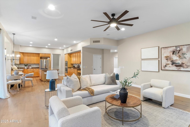 living area featuring ceiling fan, recessed lighting, visible vents, baseboards, and light wood finished floors