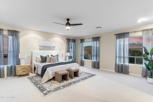 bedroom with carpet floors, ceiling fan, visible vents, and baseboards