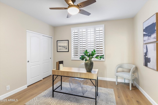 office with light wood finished floors, a ceiling fan, and baseboards