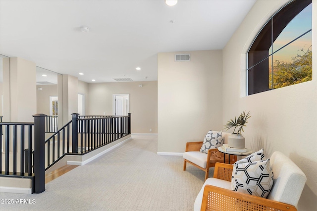 hall featuring visible vents, baseboards, carpet, an upstairs landing, and recessed lighting