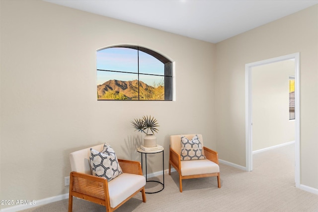 sitting room featuring light carpet and baseboards