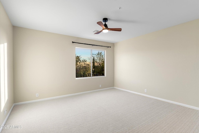 spare room featuring carpet floors, baseboards, and a ceiling fan