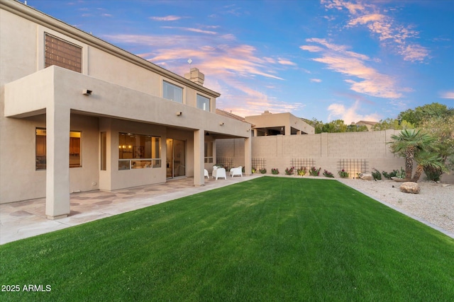 yard at dusk with a patio area and fence