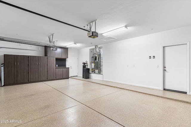 garage featuring a garage door opener and baseboards