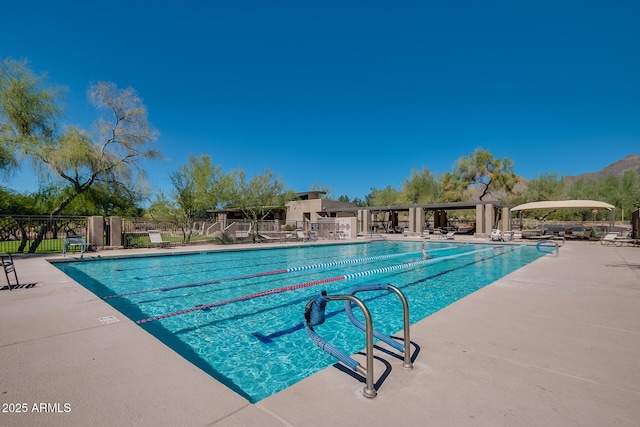 pool with a patio area and fence