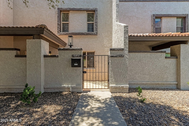 4918 N 74th St, Scottsdale, AZ 85251 - property entrance with a gate, stucco siding, and a tiled roof
