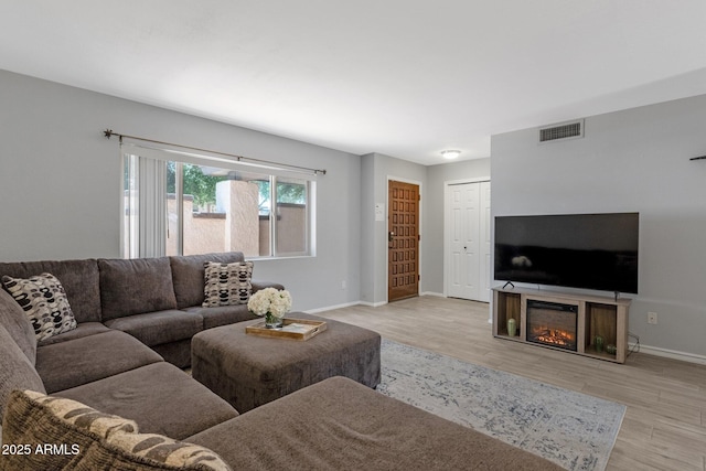 4918 N 74th St, Scottsdale, AZ 85251 - living area featuring light wood finished floors and a glass covered fireplace