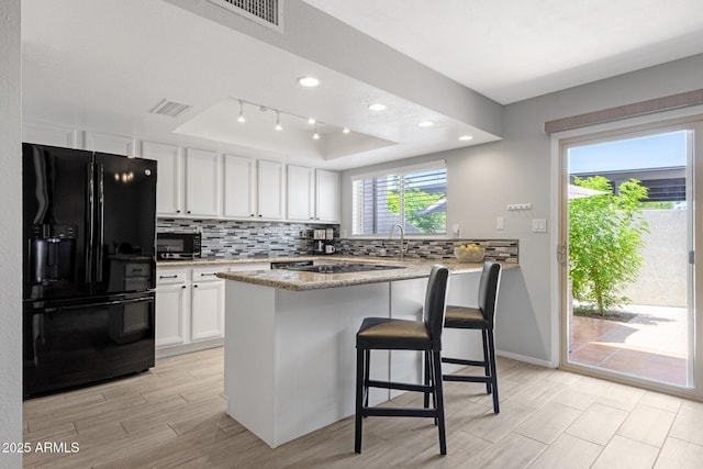 4918 N 74th St, Scottsdale, AZ 85251 - kitchen featuring black appliances, tasteful backsplash, healthy amount of natural light, and recessed lighting
