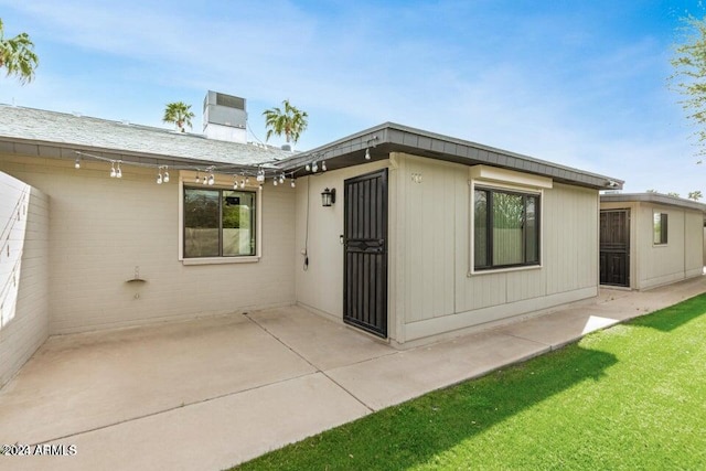 back of property with a yard and a patio area