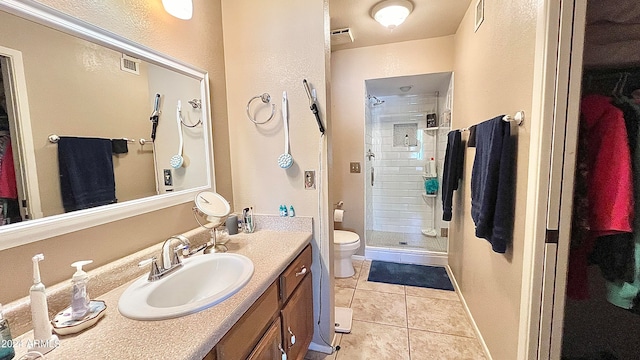 bathroom with large vanity, tile floors, toilet, and an enclosed shower