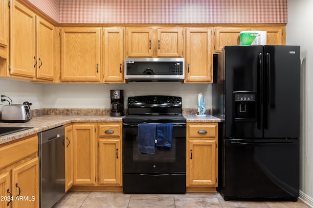 kitchen with light tile floors and black appliances