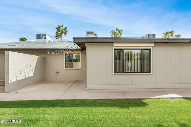 back of property with a patio area and a lawn