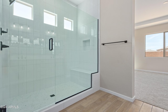 full bathroom with a stall shower, baseboards, and wood finished floors