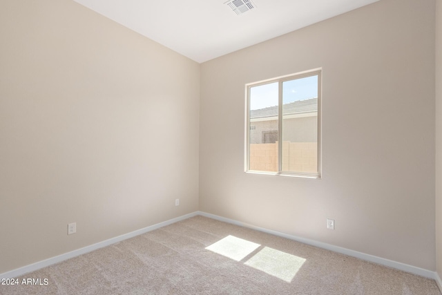 carpeted spare room with visible vents and baseboards