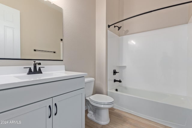 full bath with vanity, bathing tub / shower combination, wood finished floors, and toilet