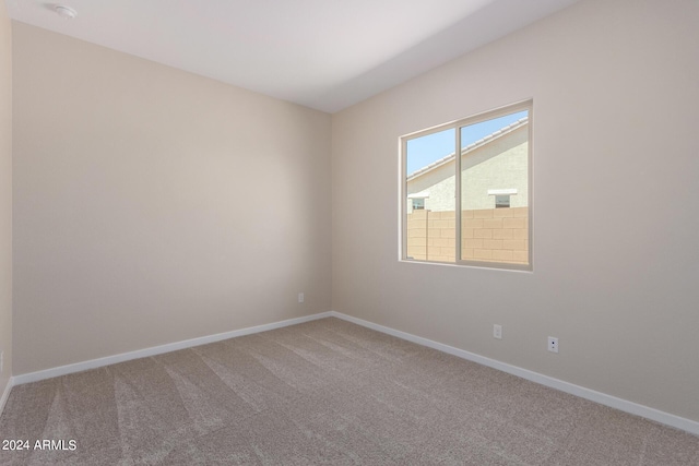 empty room featuring carpet and baseboards