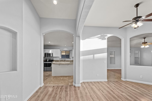 interior space with ceiling fan, sink, and light hardwood / wood-style floors