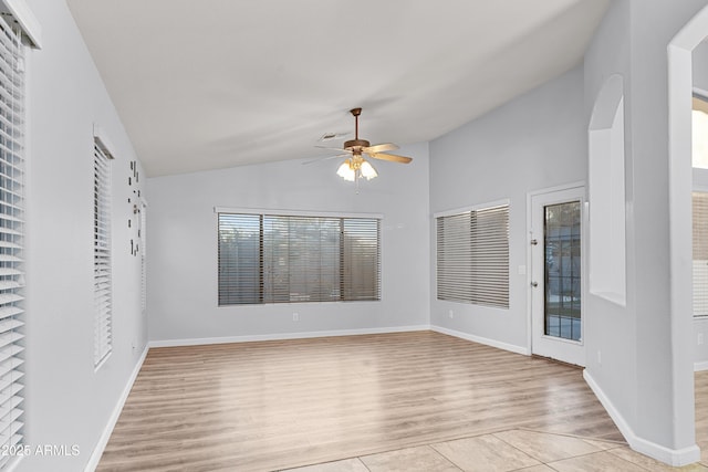 tiled empty room with ceiling fan and lofted ceiling