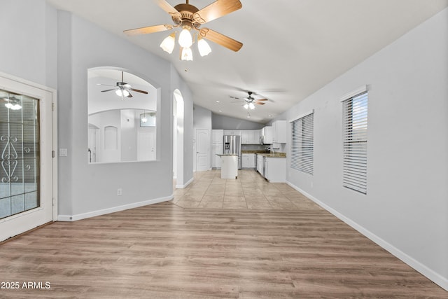 unfurnished living room with lofted ceiling and light wood-type flooring