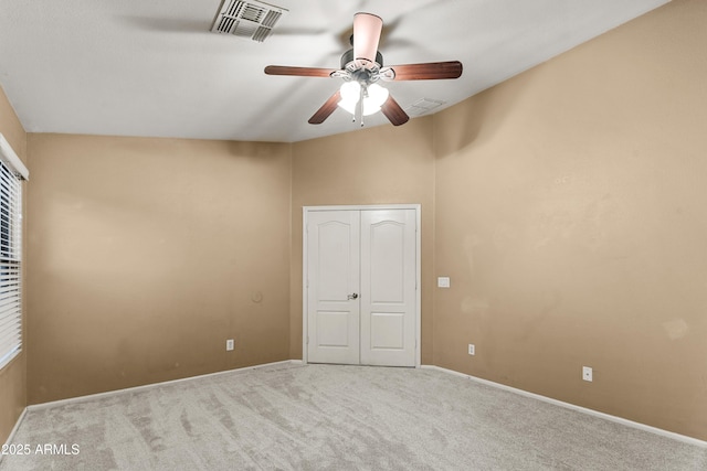 unfurnished bedroom with ceiling fan, light carpet, and a closet