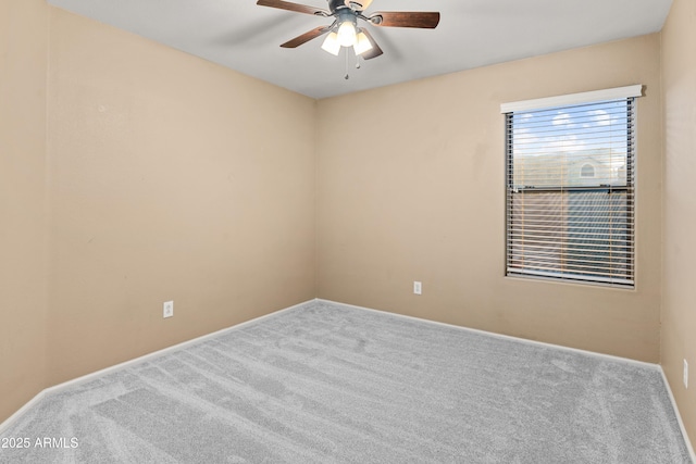 carpeted spare room with ceiling fan