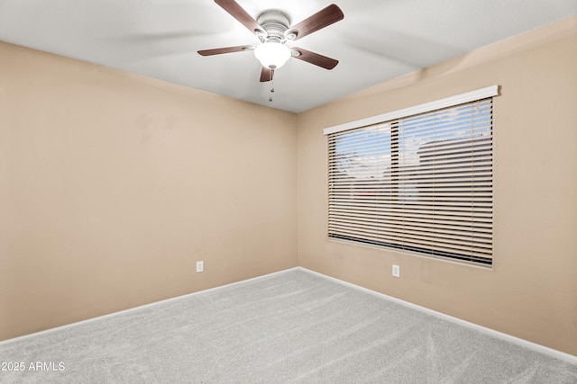 unfurnished room with ceiling fan and carpet