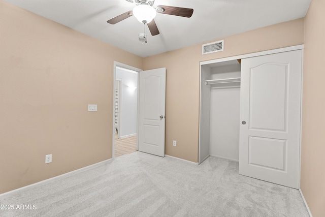 unfurnished bedroom featuring ceiling fan, a closet, and light carpet