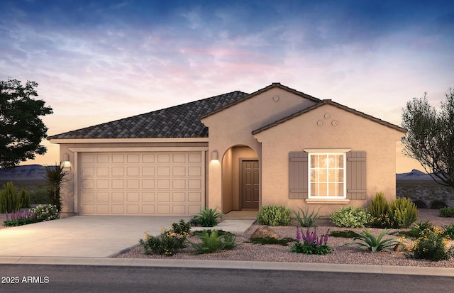 view of front of property with driveway, a garage, and stucco siding