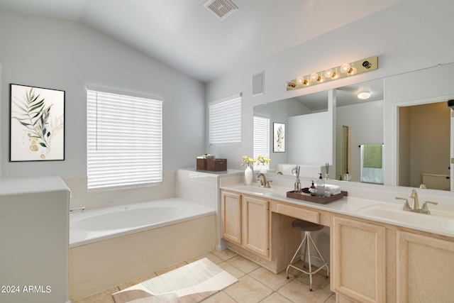 bathroom featuring toilet, vaulted ceiling, vanity, a bath, and tile patterned flooring