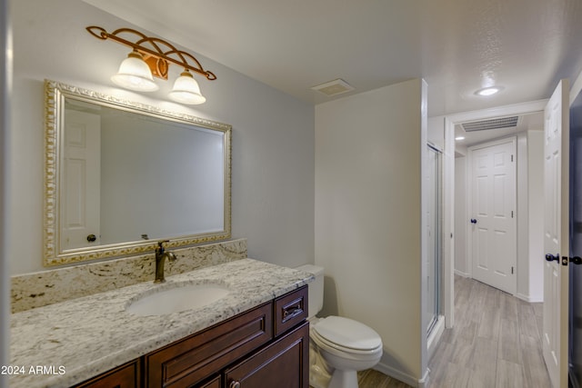 bathroom with vanity, an enclosed shower, hardwood / wood-style flooring, and toilet