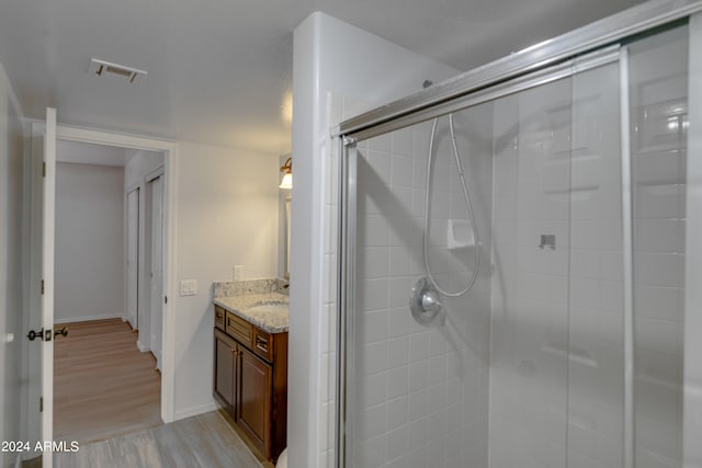 bathroom featuring a shower with door, wood-type flooring, and vanity