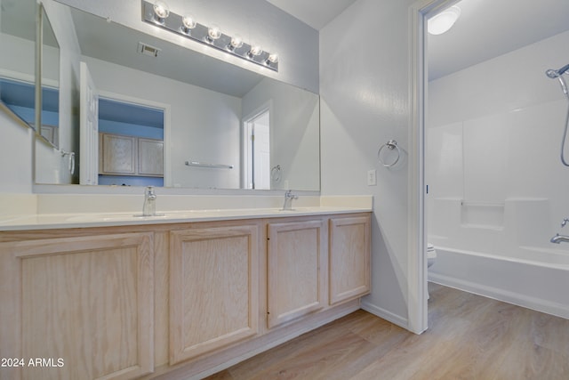 full bathroom with vanity, hardwood / wood-style flooring, toilet, and shower / bath combination