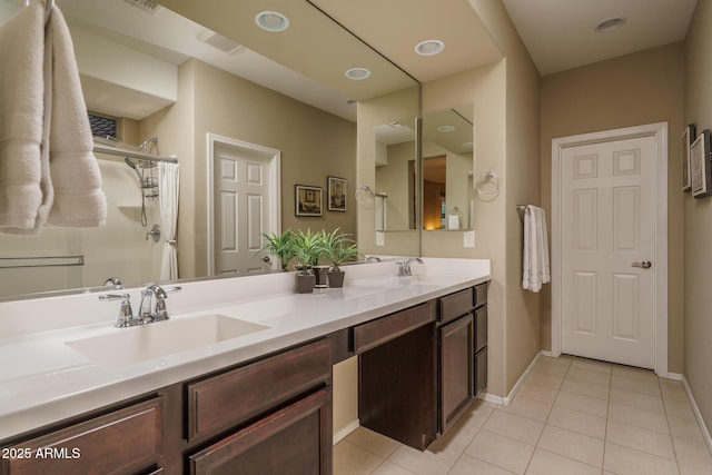 full bathroom featuring tile patterned floors, a shower, double vanity, and a sink